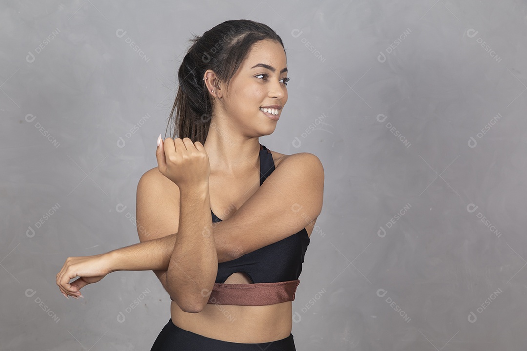 Linda mulher jovem garota sorridente  se alongando exercícios sobre fundo isolado cinza