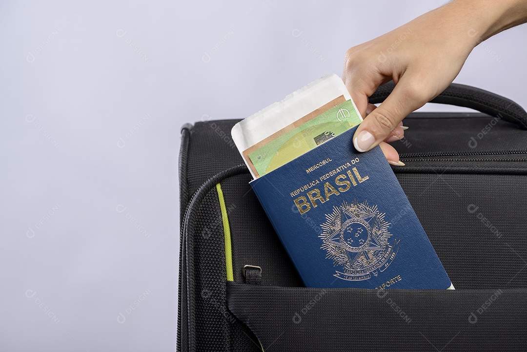 Passaporte brasileiro sendo colocado na mala.
