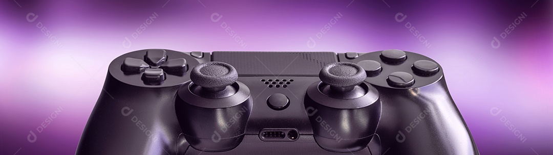 Controlador de videogame preto isolado em um fundo lilás desfocado - conceito de tecnologia e videogame