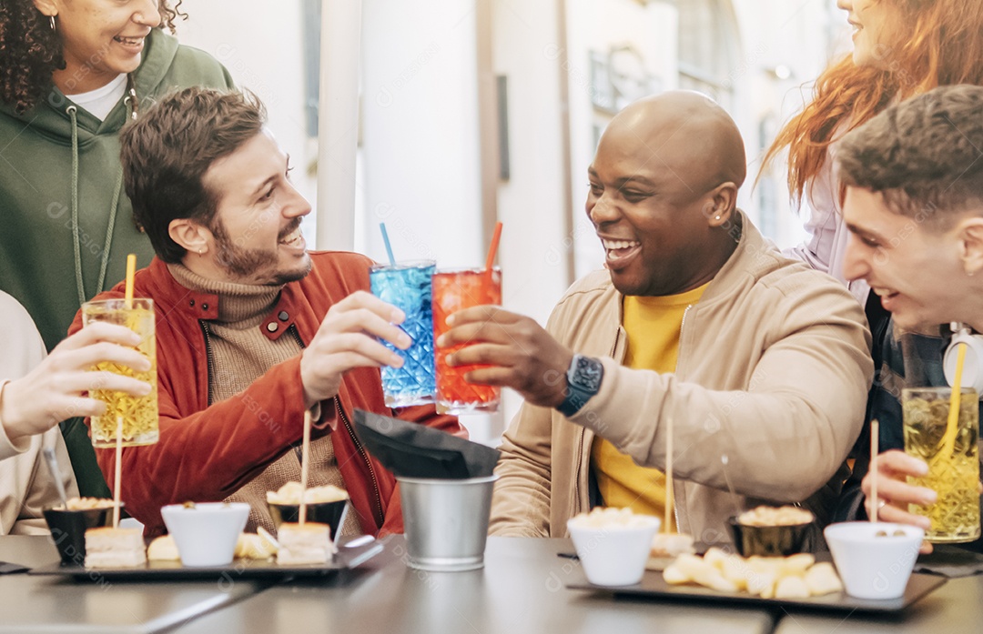 Felizes amigos multirraciais brindam, bebem e comem na reunião do restaurante - Conceito de estilo de vida com amigos hipsters compartilhando happy hour juntos - Foco seletivo