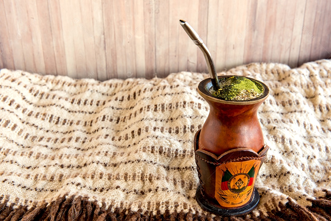 Tradição gaúcha, poncho e chimarrão de erva-mate.