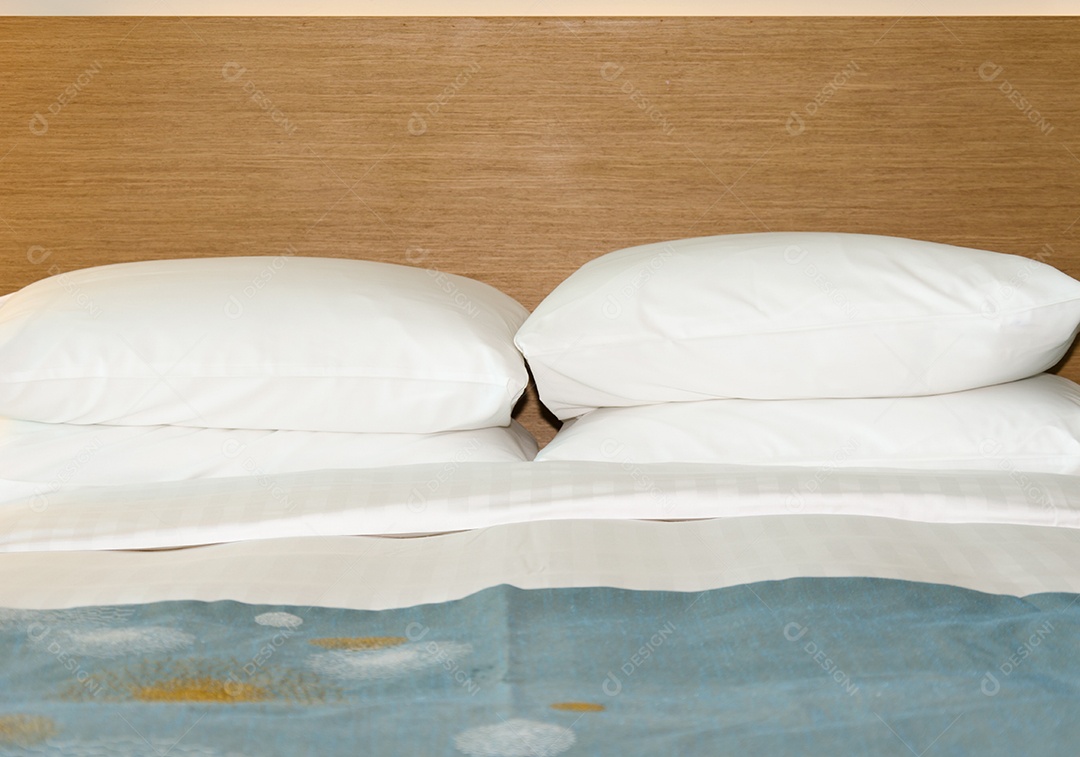 Almofadas na cama no quarto de hotel arrumadas.