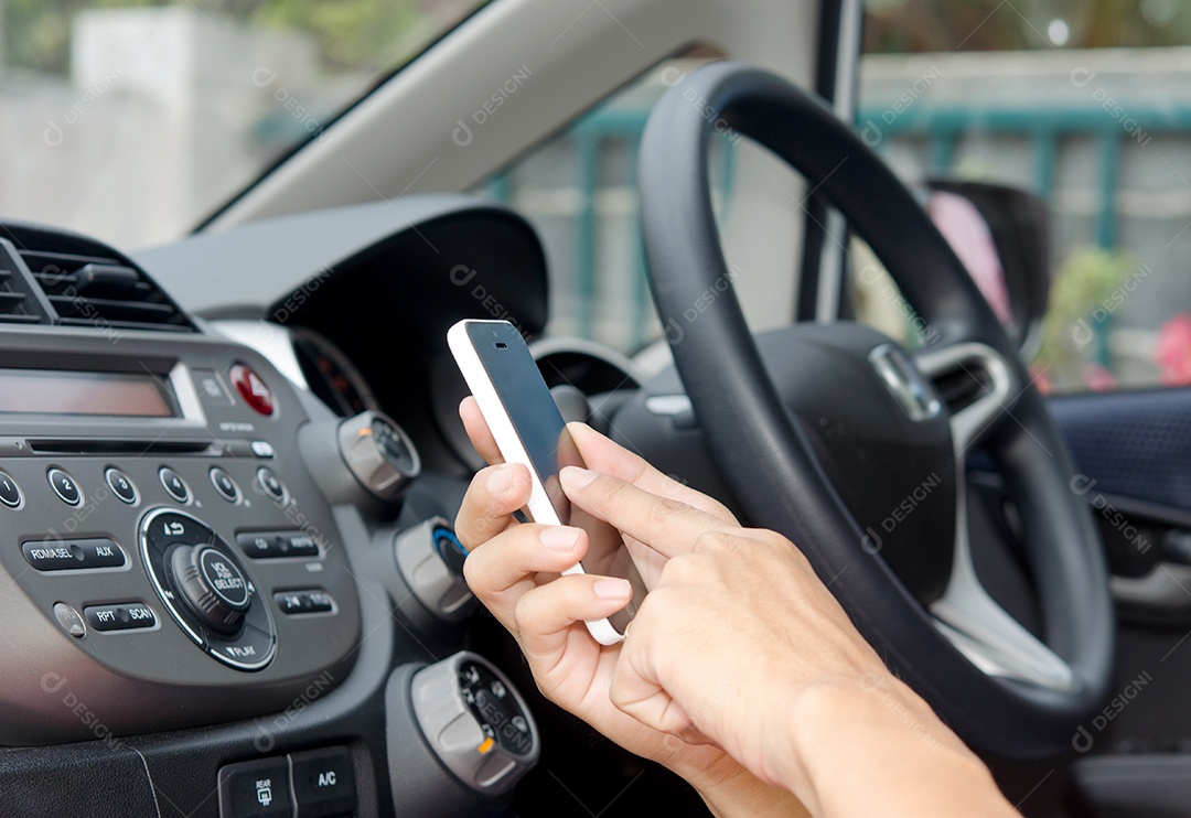 homem sentado no carro com celular na mão