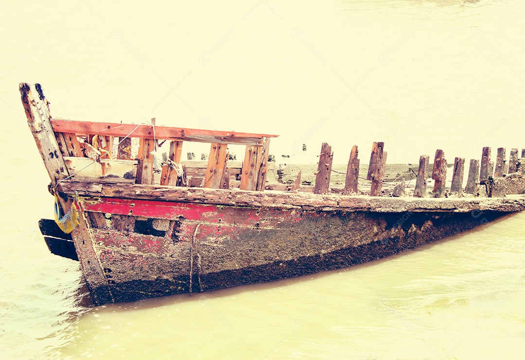 Naufrágio de navio de madeira velho na água.