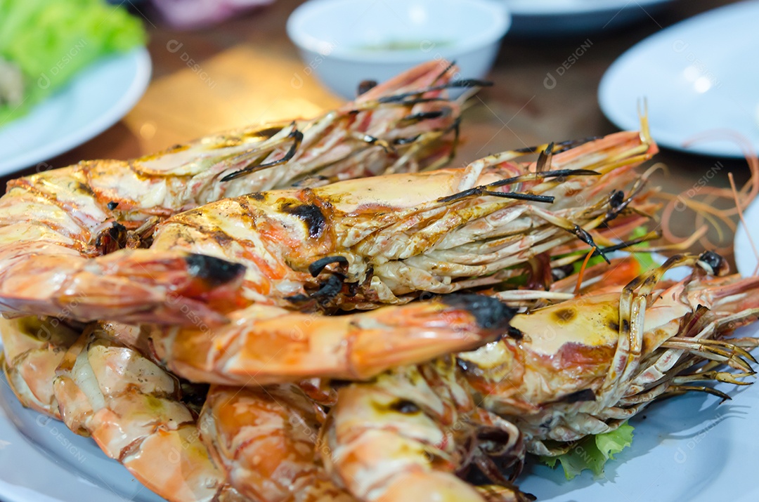 Detalhe de camarões grelhados no prato.