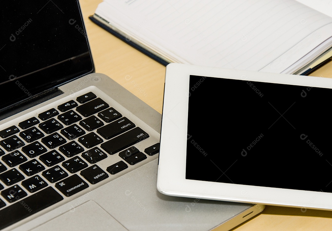 Notebook e livro colocados nas mesas.