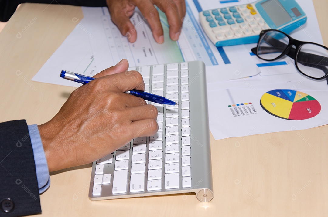 Mão e documento na mesa e teclado.