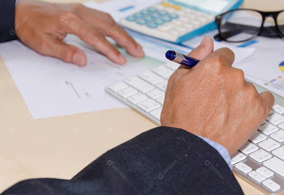 Mão e documento na mesa e teclado.