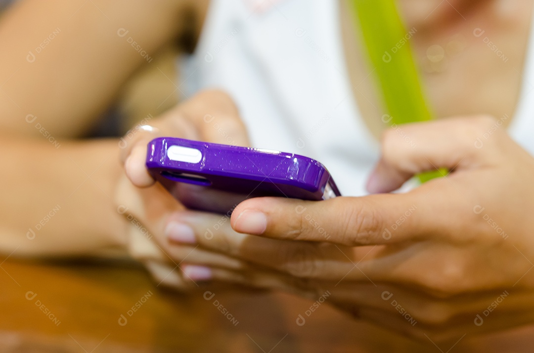 Telefone inteligente na mão na mesa.
