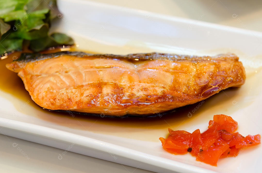 Salmão grelhado com molho de soja no prato.