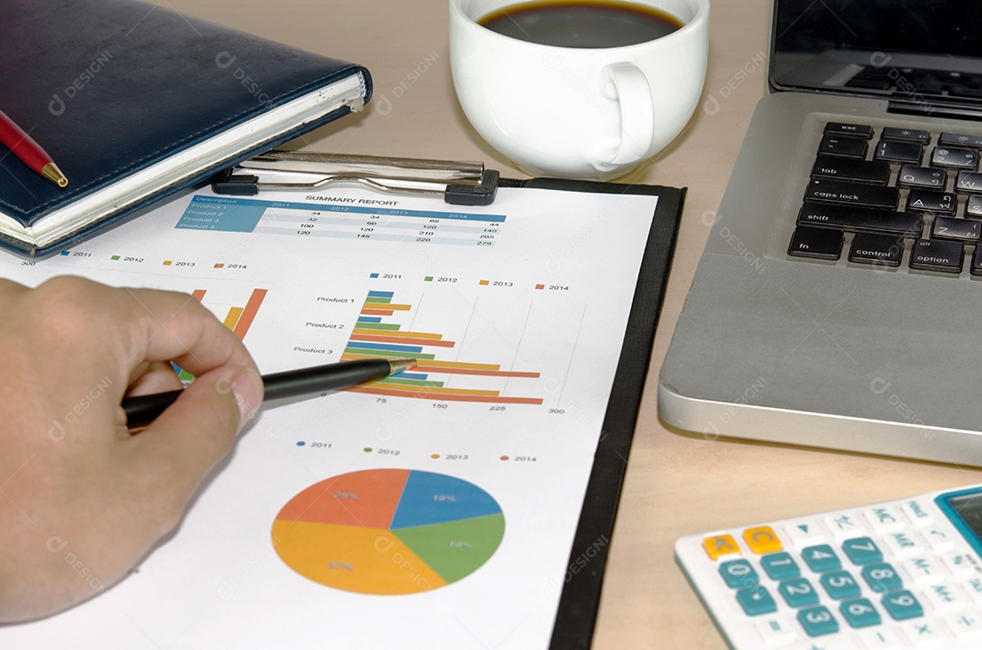 Documentos de negócios analisando gráficos de investimento com laptop.