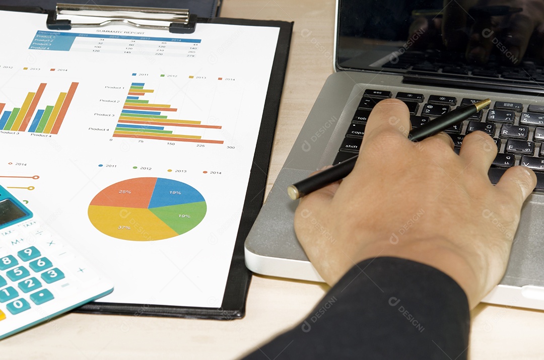 Documentos de negócios analisando gráficos de investimento com laptop.