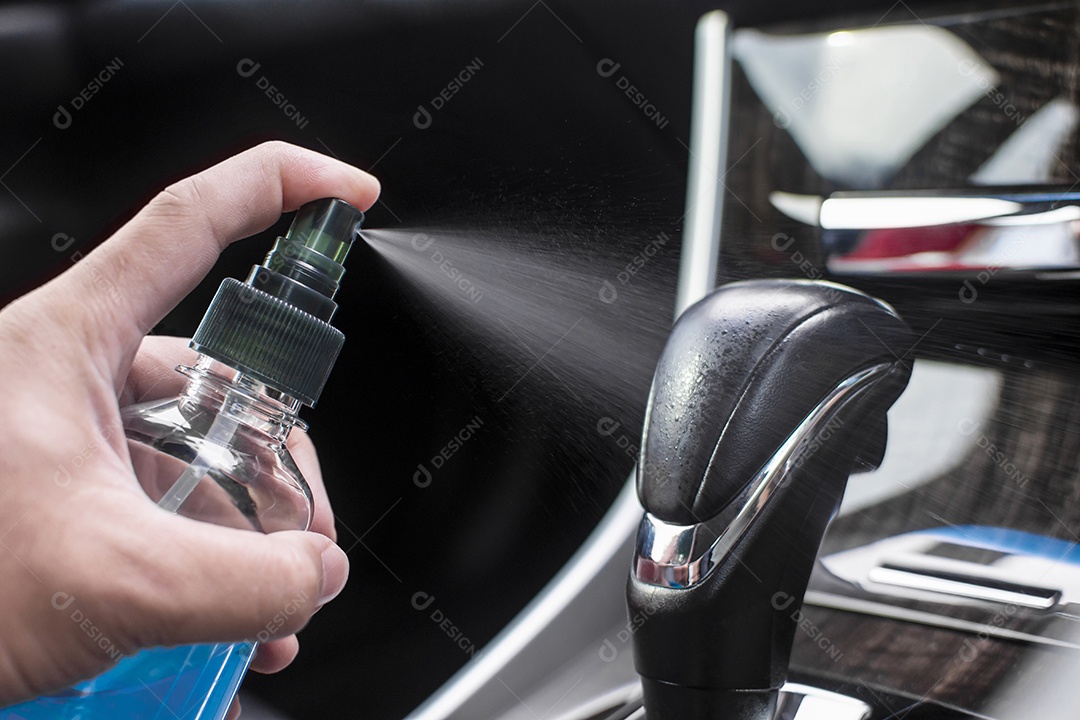 Cleaning car door handle inside with alcohol sanitizing spray in a car for protection disease and antibacterial , Coronavirus (COVID-19) prevention concept