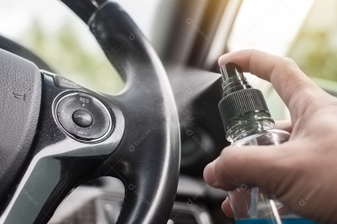 Volante de limpeza com spray desinfetante de álcool em um carro para proteção contra doenças e antibacteriano, conceito de prevenção de Coronavírus (COVID-19)