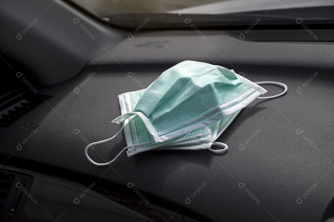 Máscara facial médica colocada no assento de couro dentro do carro, conceito de prevenção de Coronavírus (COVID-19)