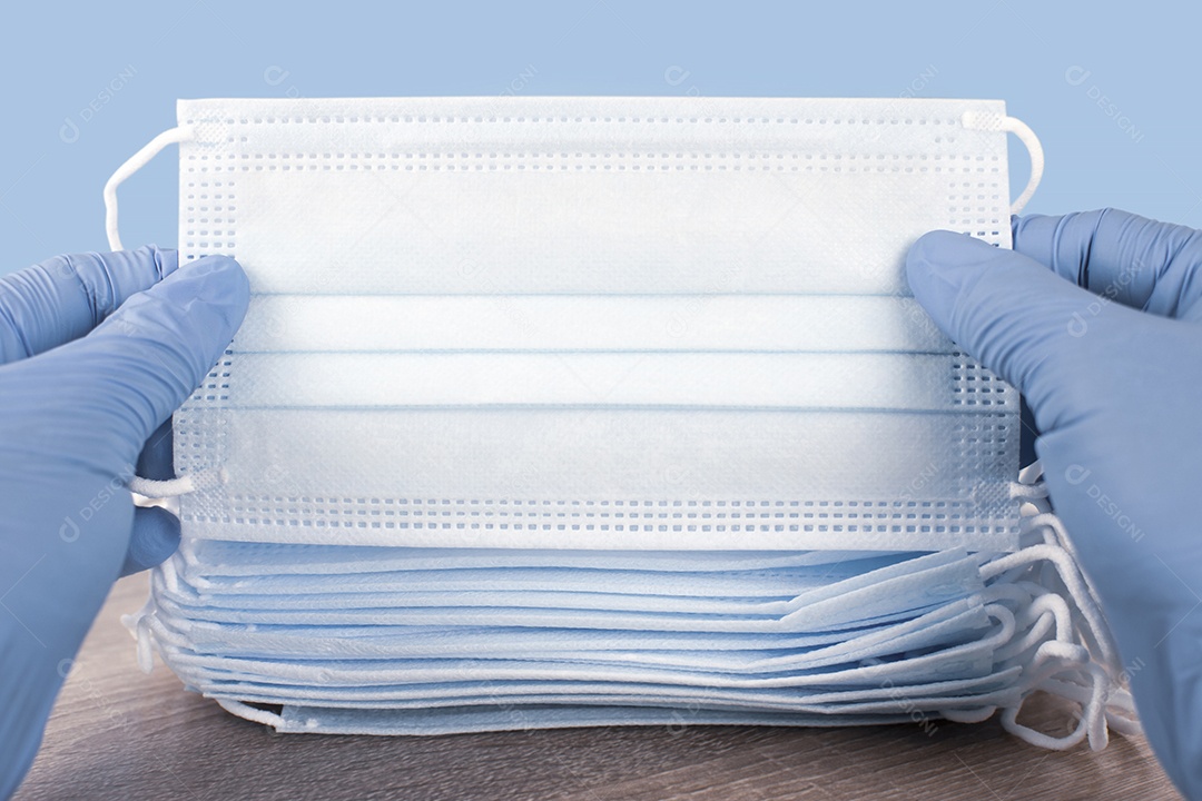 Pessoa mostrando detalhes de máscara de proteção facial contra COVID-19.