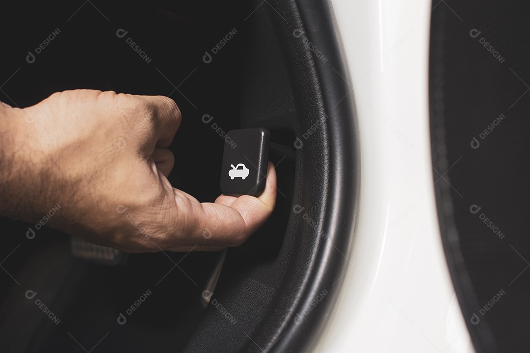 A mão do técnico está puxando o botão do capô para abrir o capô do carro