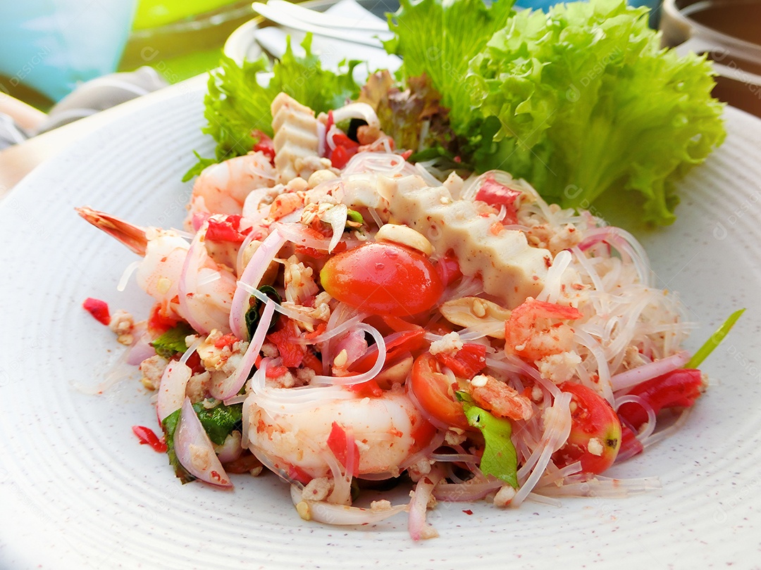 Close-up de salada de aletria mista de frutos do mar picante com vegetais em um prato branco