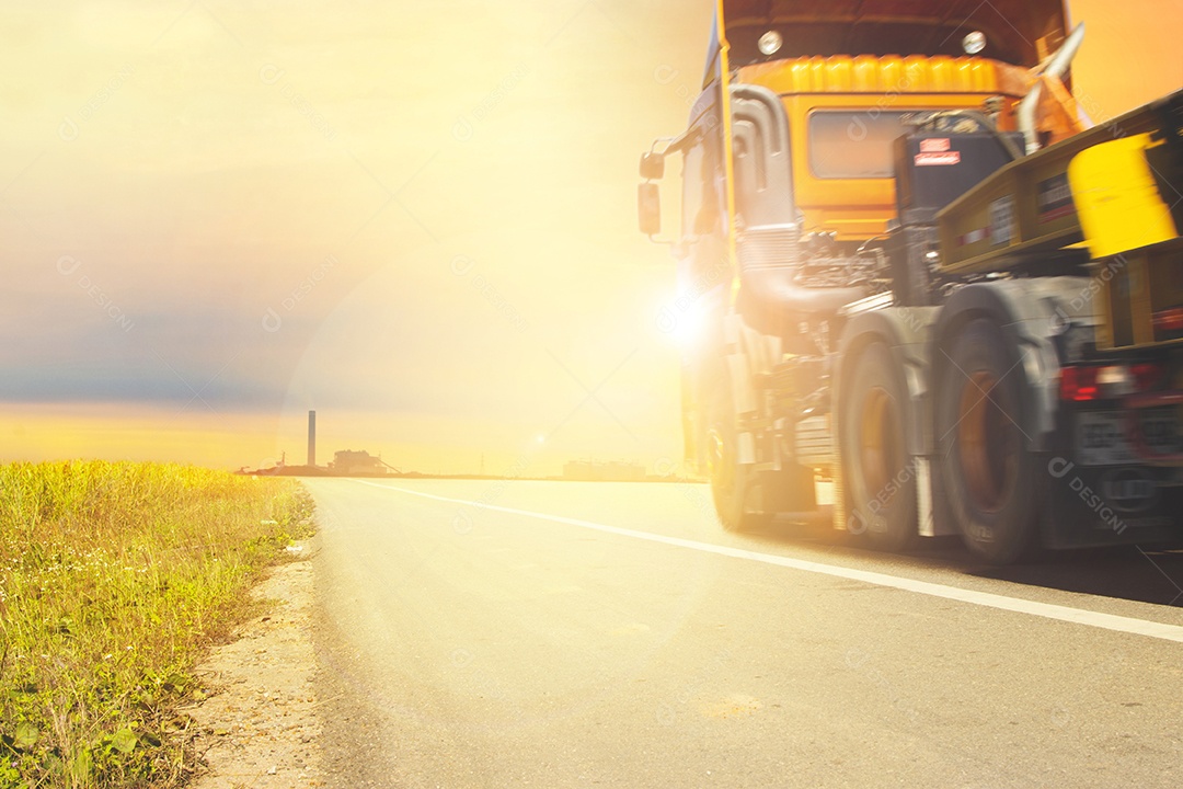 A estrada rodoviária para a propriedade industrial ao pôr do sol e os caminhões estavam dirigindo com espaço de cópia