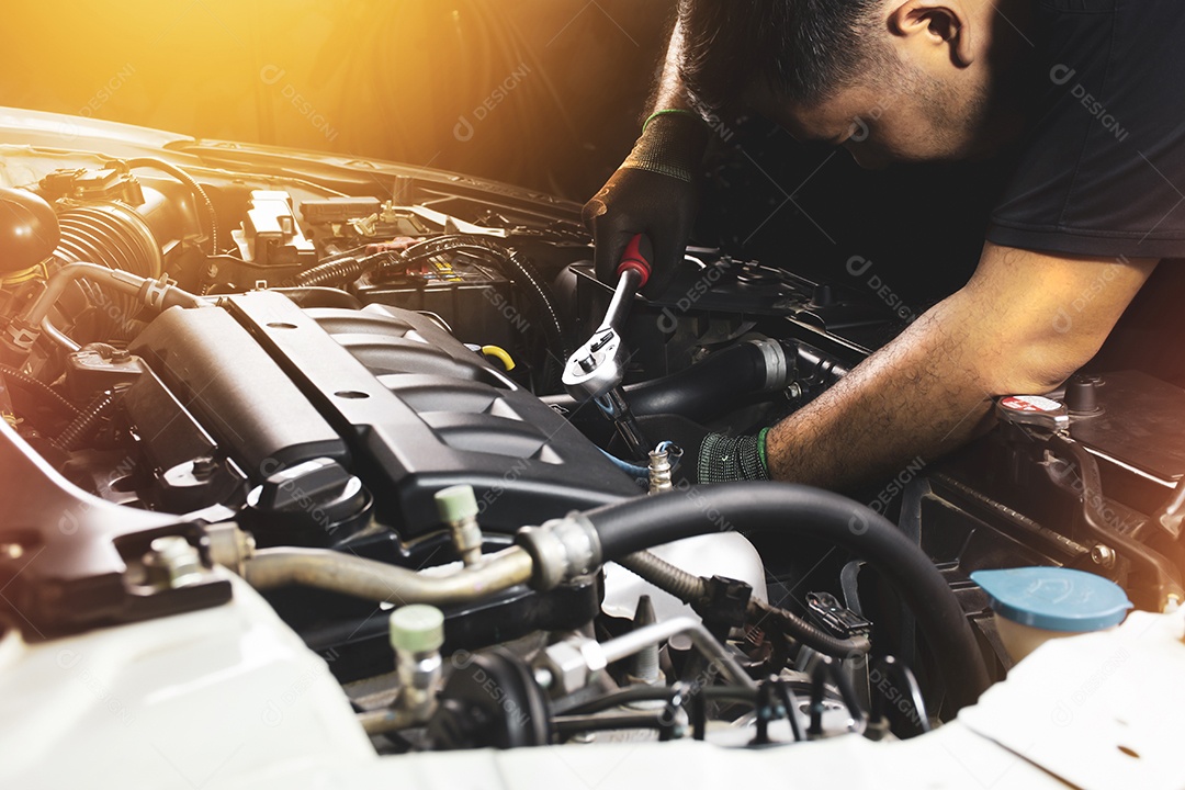 A mão do mecânico usando luvas pretas prende o parafuso com a chave de soquete para reparar o motor do carro