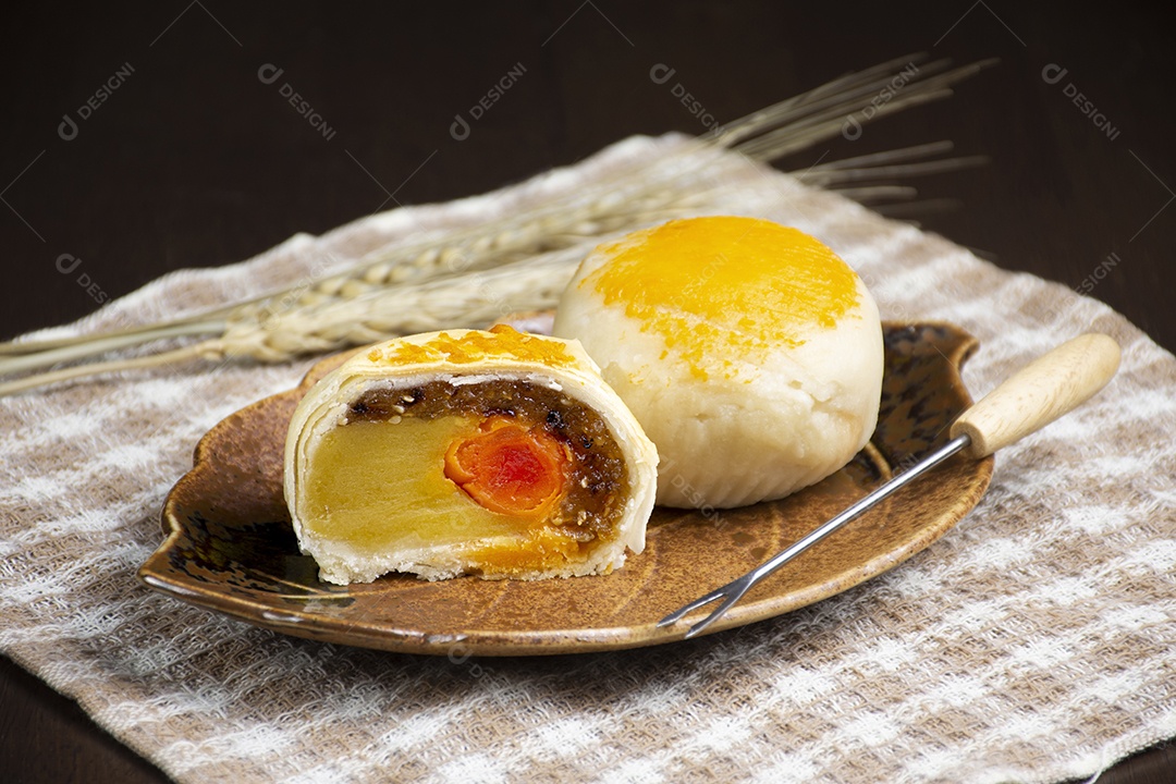 Bolo da lua, pastelaria chinesa com ovo salgado no prato na mesa de madeira