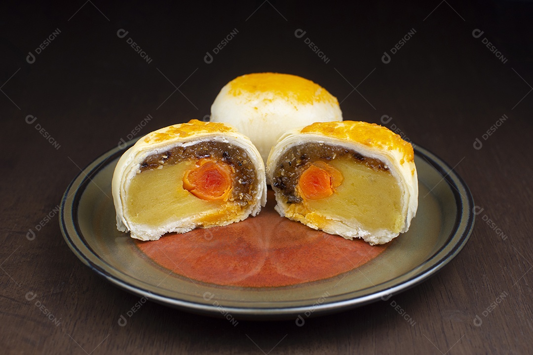 Moon cake, Chinese pastry with salted egg on plate on wooden table