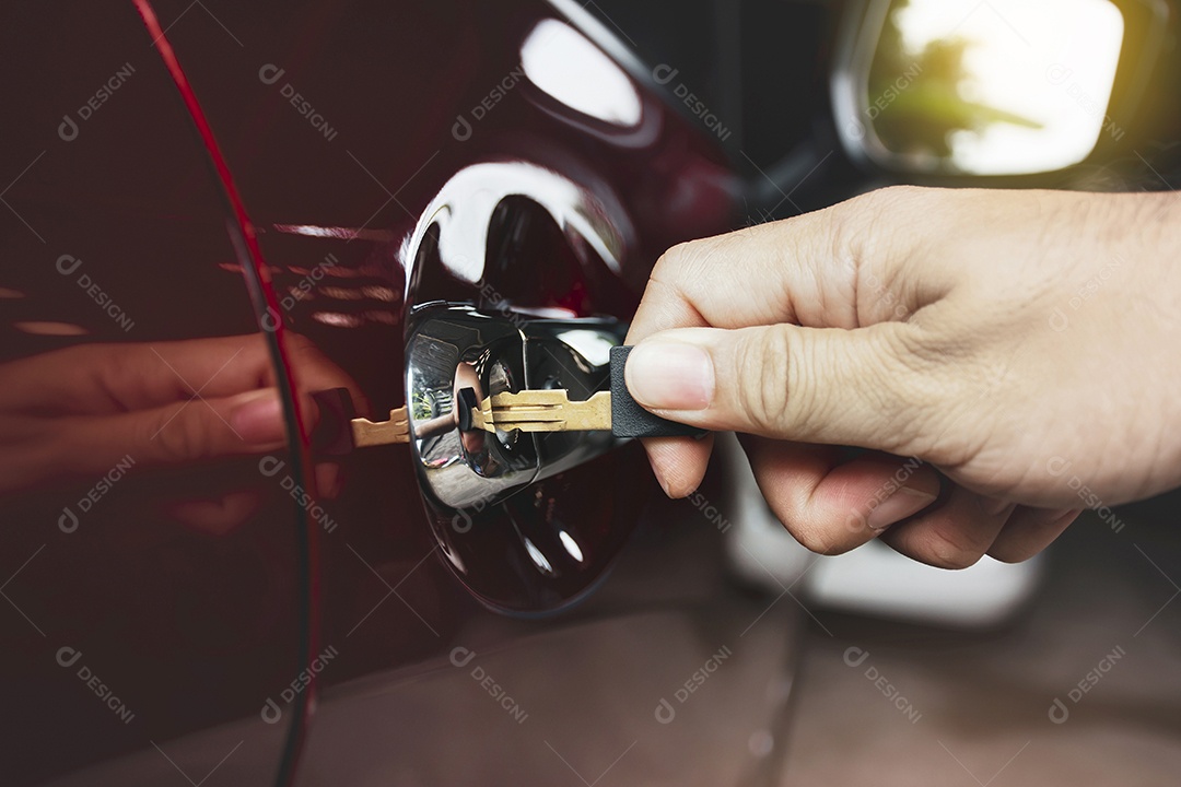 A mão humana está destravando a porta do carro com a chave na garagem