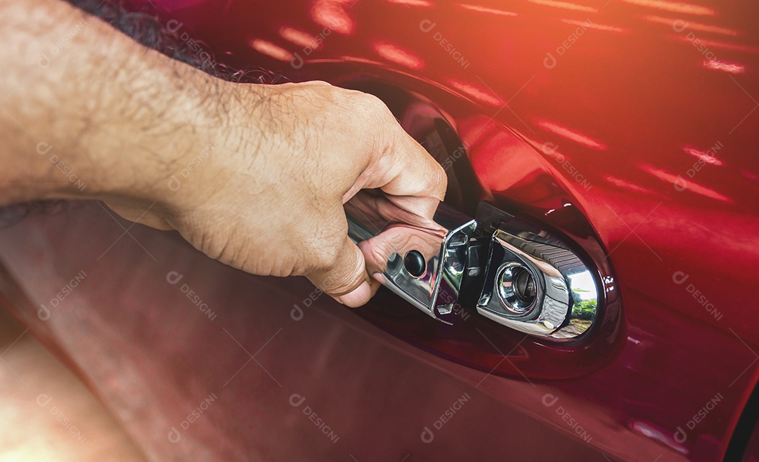 A mão humana está destravando a porta do carro na garagem
