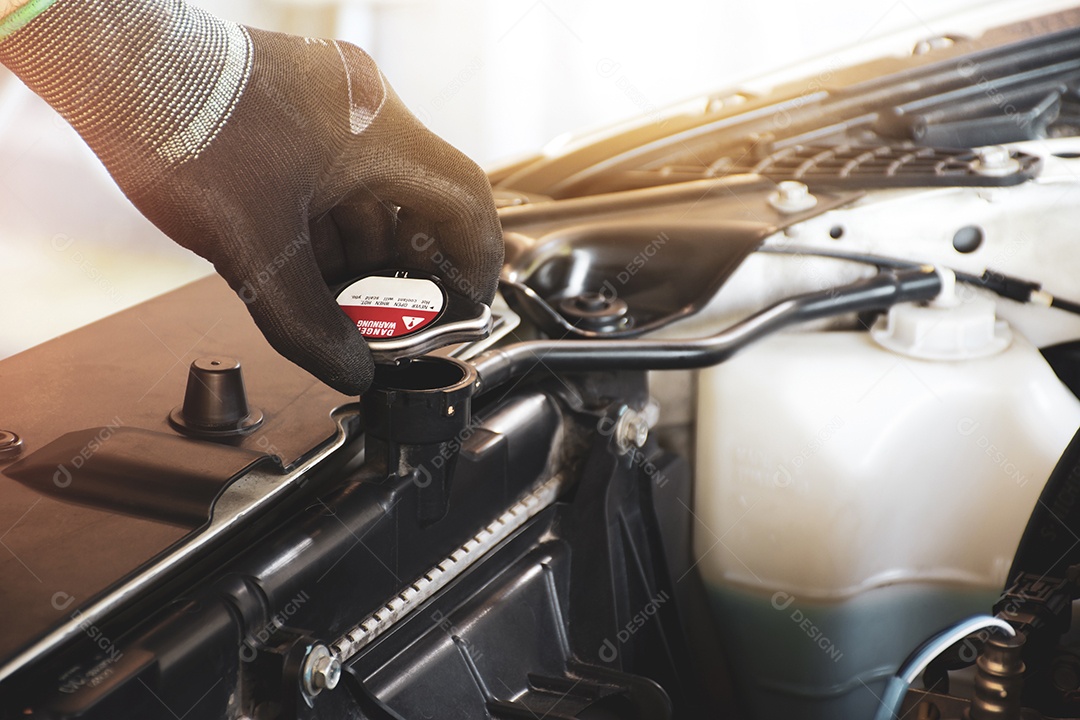 A mão do mecânico está abrindo a tampa do radiador para verificar o nível do líquido de arrefecimento do radiador do carro