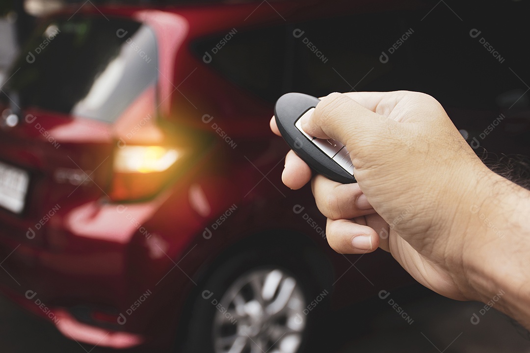 A mão humana está pressionando o botão de bloqueio ou desbloqueio do controle remoto sem chave do carro