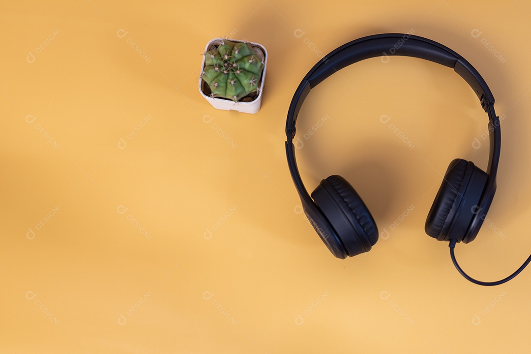 Fones de ouvido e cactos no espaço de cópia de fundo amarelo.