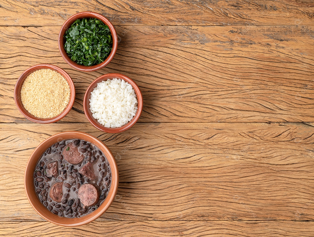 Feijoada típica brasileira com farofa, arroz, couve e espaço para copiar.