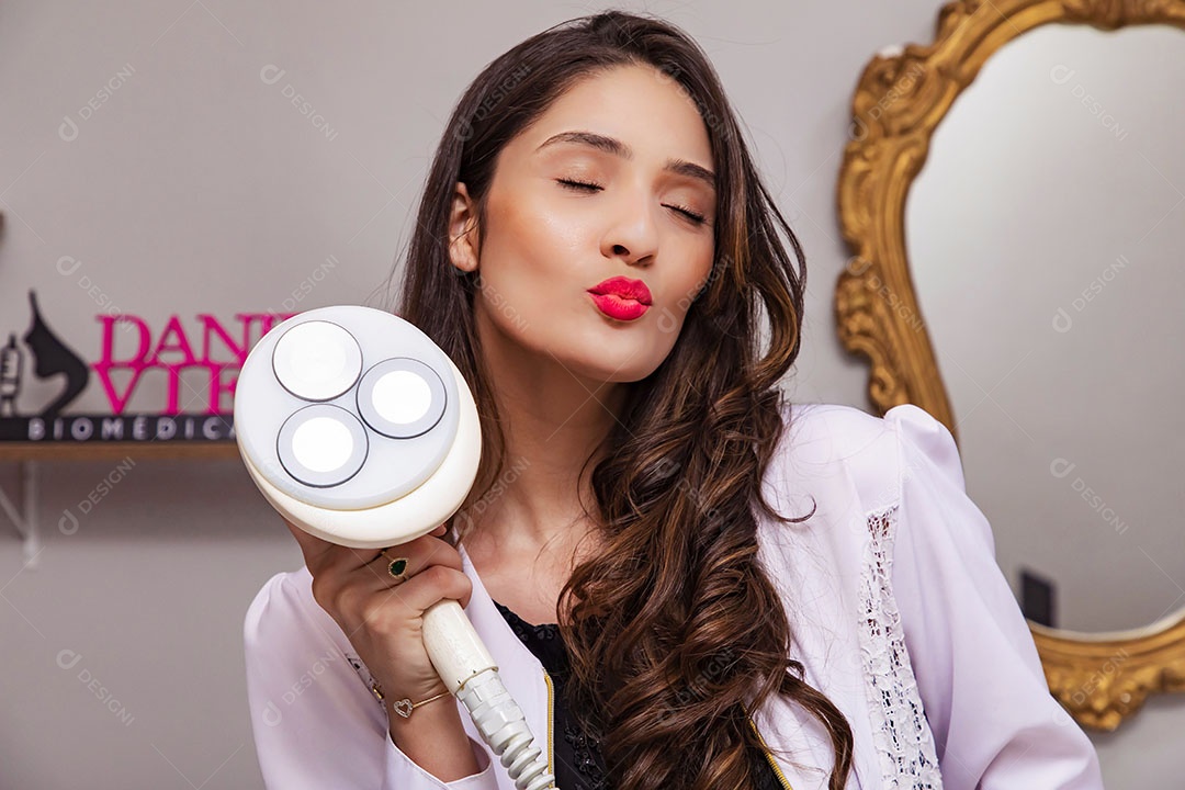 Jovem mulher segurando aparelho estético