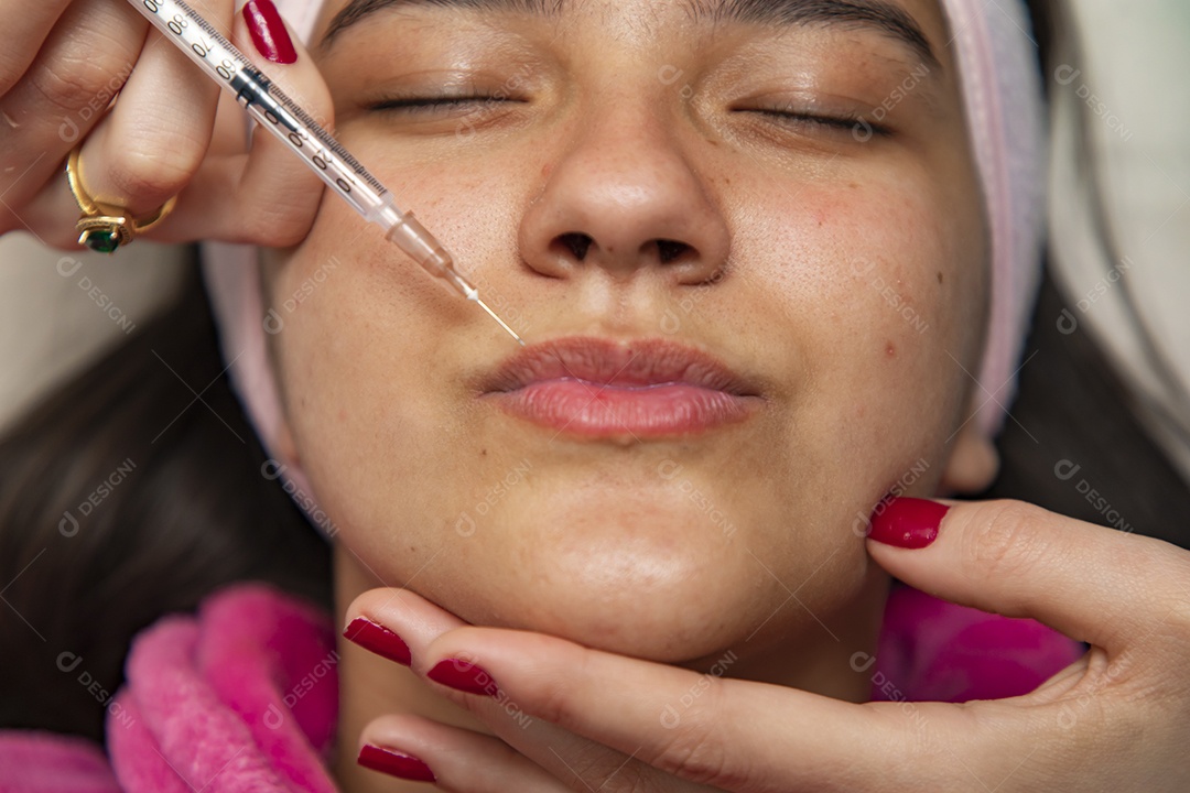 Mulher jovem recebendo procedimentos estéticos por uma profissional do ramo