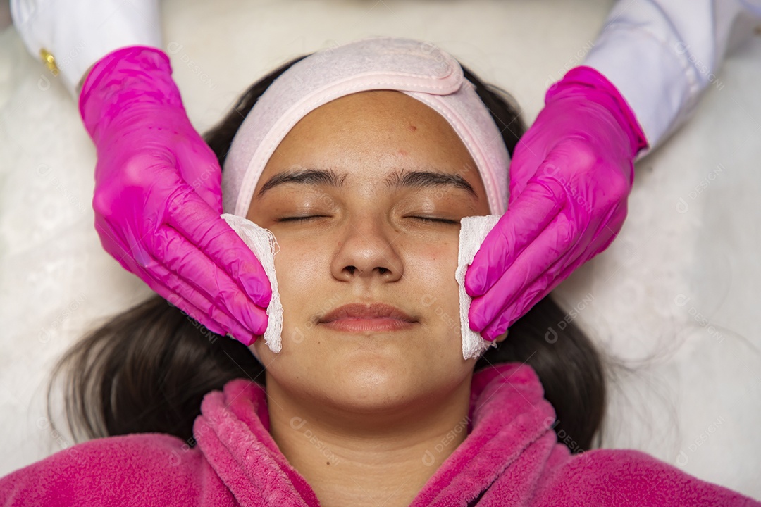 Mulher jovem recebendo procedimentos estéticos por uma profissional do ramo