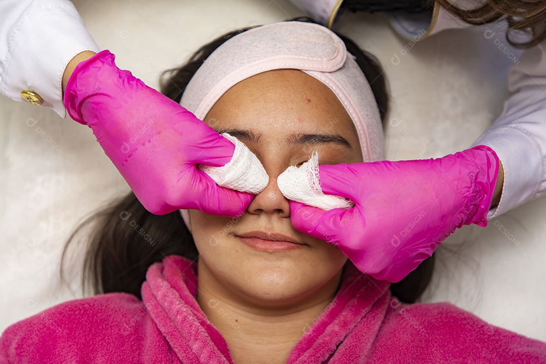 Mulher jovem recebendo procedimentos estéticos por uma profissional do ramo