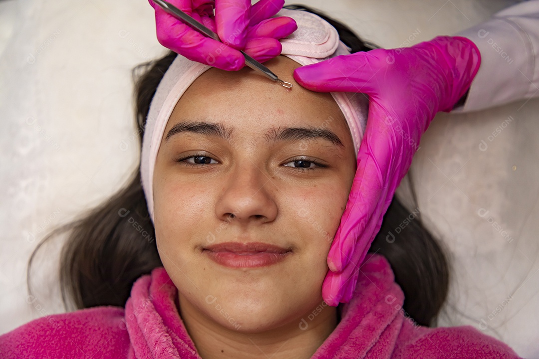 Mulher jovem recebendo procedimentos estéticos por uma profissional do ramo