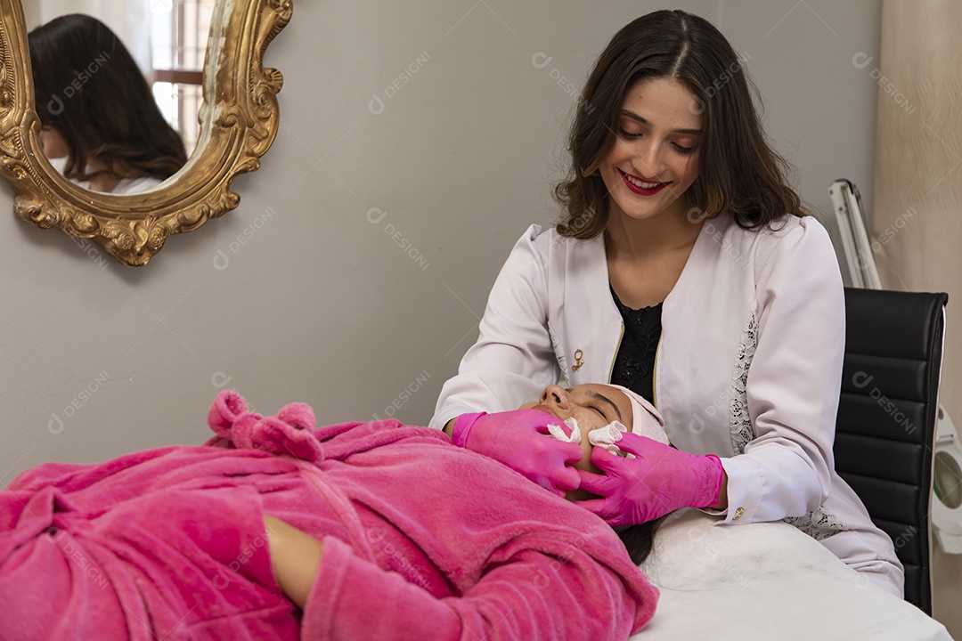 Mulher jovem empresaria no ramo da biomedicina e estética fazendo procedimentos em uma linda jovem