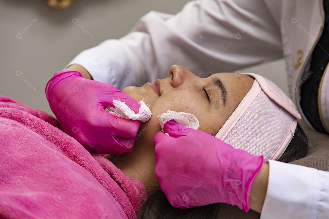 Mulher jovem recebendo procedimentos estéticos por uma profissional do ramo