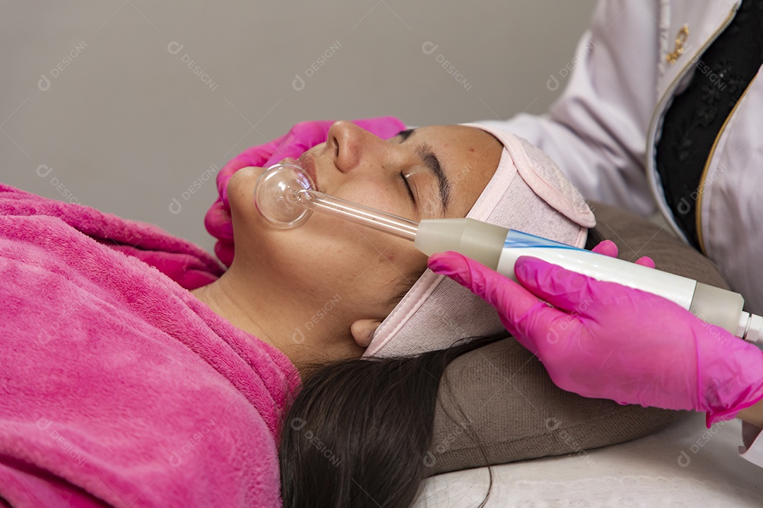 Mulher jovem recebendo procedimentos estéticos por uma profissional do ramo