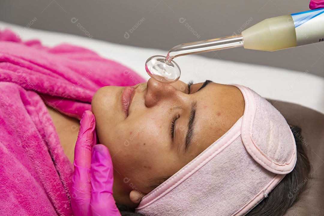 Mulher jovem recebendo procedimentos estéticos por uma profissional do ramo