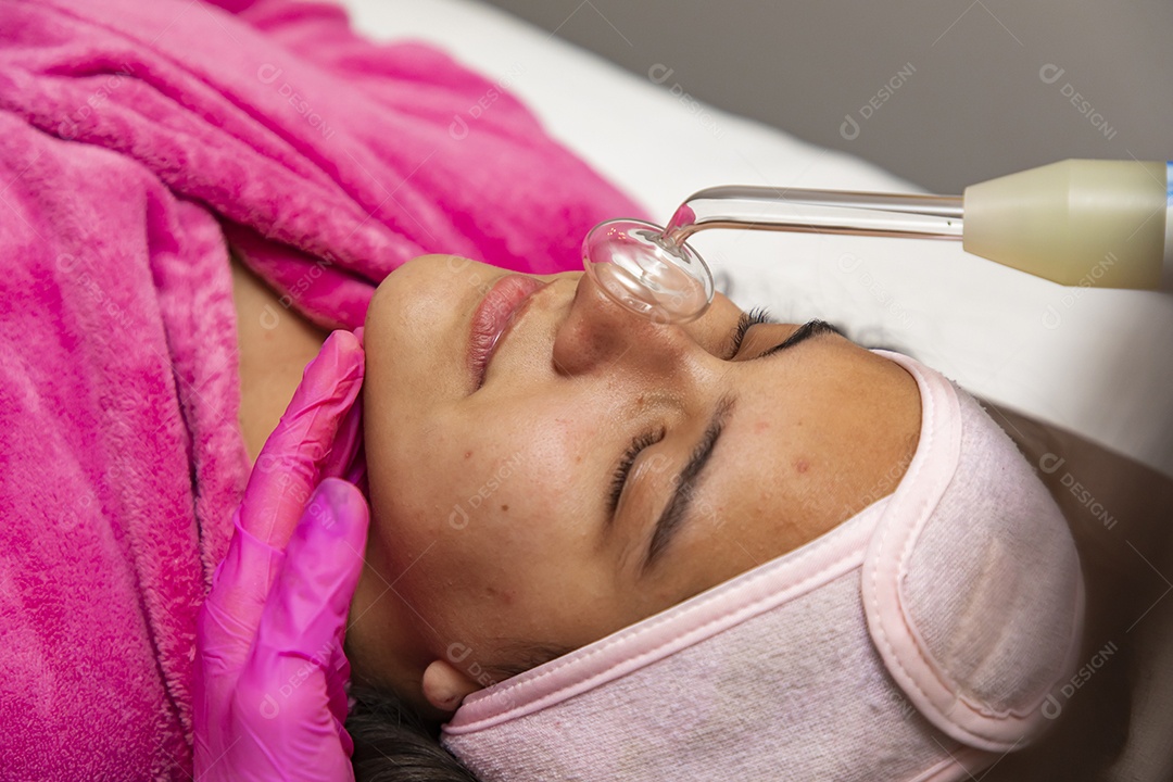 Mulher jovem recebendo procedimentos estéticos por uma profissional do ramo