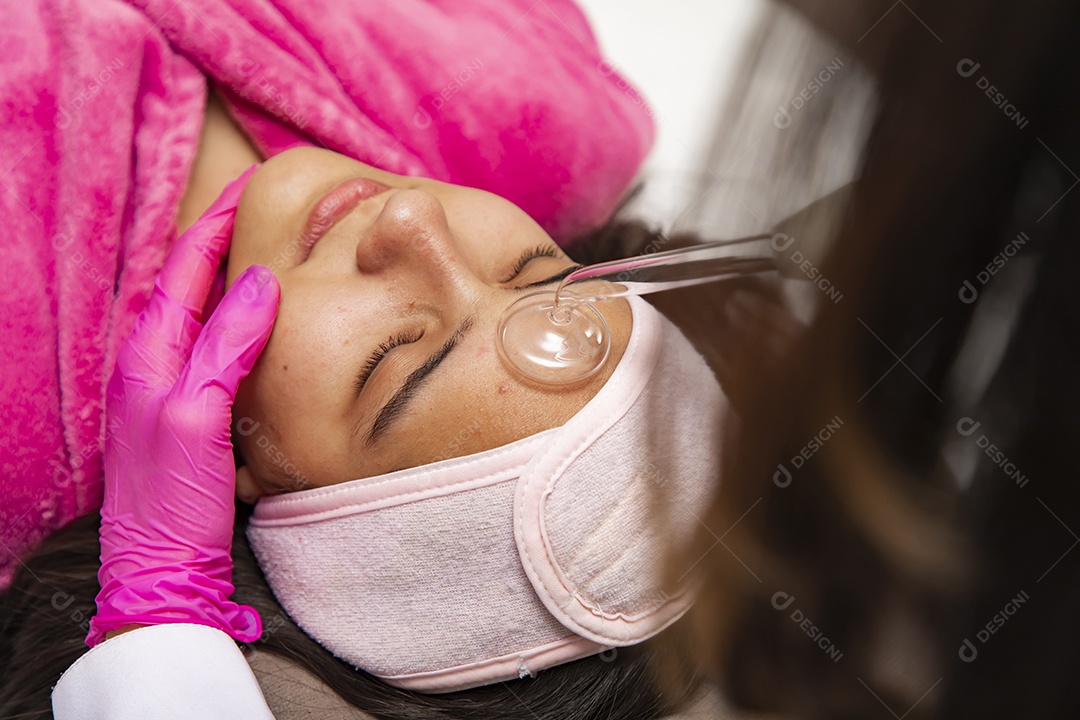 Mulher jovem recebendo procedimentos estéticos por uma profissional do ramo