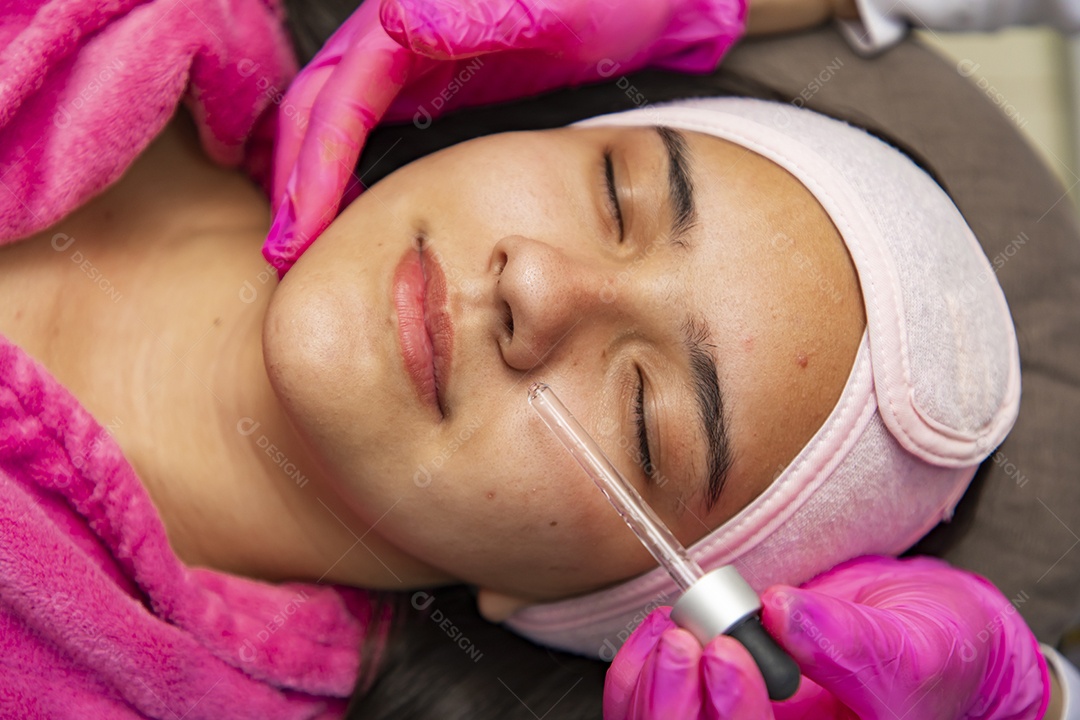Mulher jovem recebendo procedimentos estéticos por uma profissional do ramo