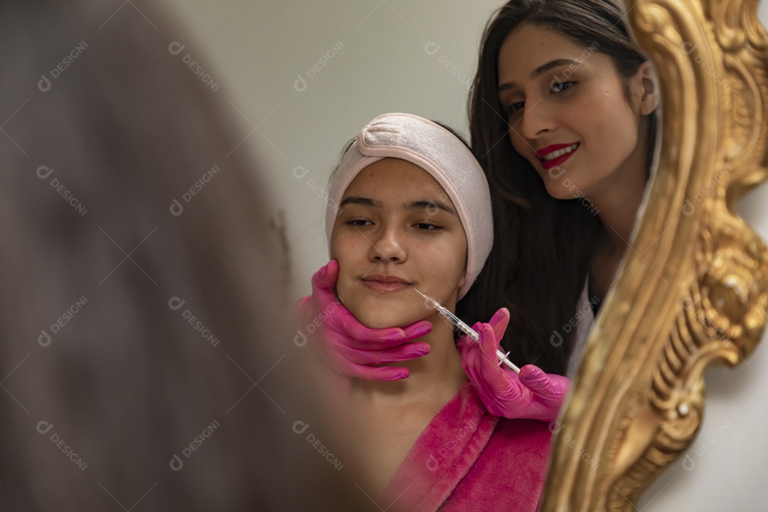 Mulher jovem empresaria no ramo da biomedicina e estética fazendo procedimentos em uma linda jovem