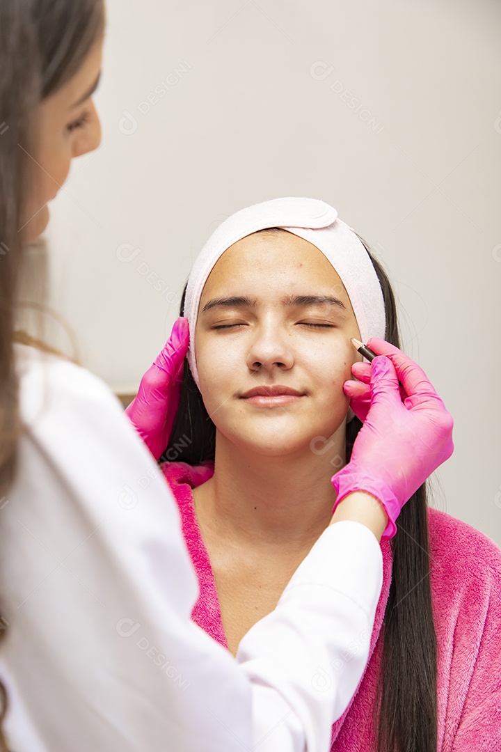 Mulher jovem recebendo procedimentos estéticos por uma profissional do ramo