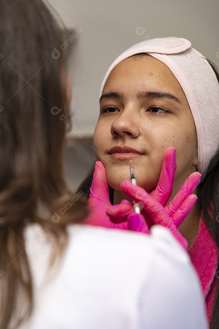 Mulher jovem empresaria no ramo da biomedicina e estética fazendo procedimentos em uma linda jovem