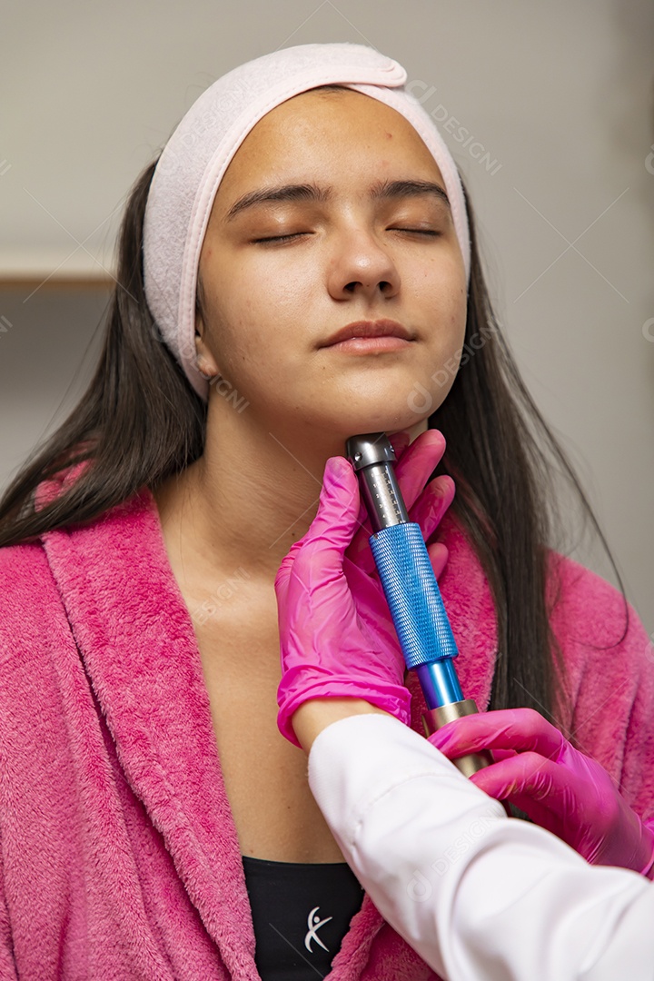 Mulher jovem empresaria no ramo da biomedicina e estética fazendo procedimentos em uma linda jovem