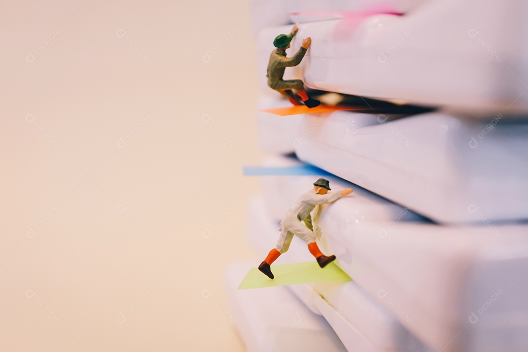 Miniaturas de homens escalando sobre livros