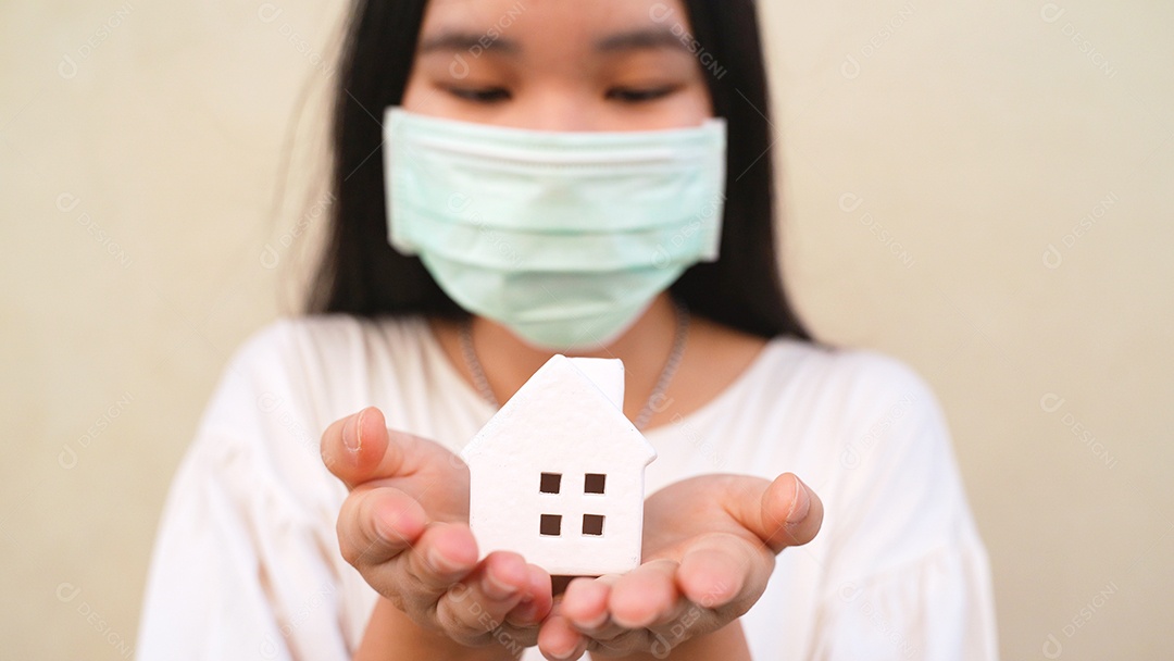 Mulher jovem asiática da geração do milênio segurando o modelo da casa branca